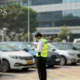 Security guard monitoring a parking space with CCTV cameras and parked cars.